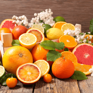 "Variety of citrus fruits on a wooden surface, including oranges, lemons, limes, and grapefruits, not recommended for chicken diets."