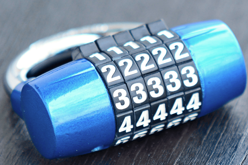 A close-up image of a combination lock with a blue body and a chrome shackle, featuring numbers on rotating dials.